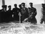 Германски офицери на посещение в концентрационния лагер Дахау; на преден план, при макета на лагера, е щандартенфюрерът от СС д-р Вилхелм Пфаненщийл; януари 1941 г. (IPN)